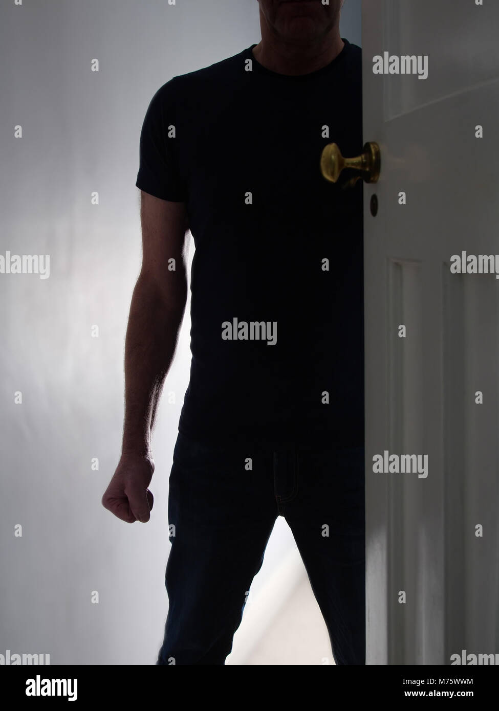 Minacciando l uomo nella porta a casa con il pugno chiuso. La violenza domestica. Foto Stock