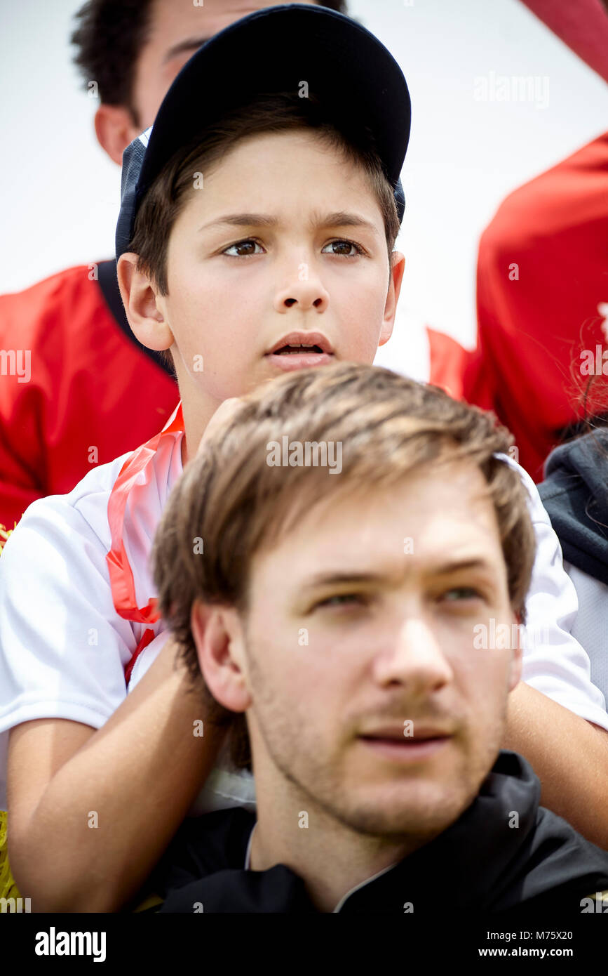 Padre e figlio guardando la partita di calcio insieme Foto Stock