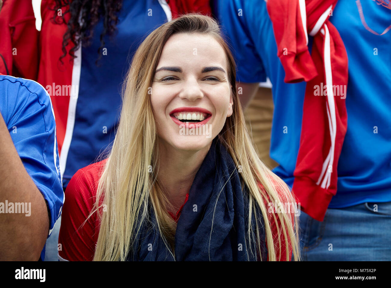 Donna guardando la partita di calcio, sorridente allegramente Foto Stock