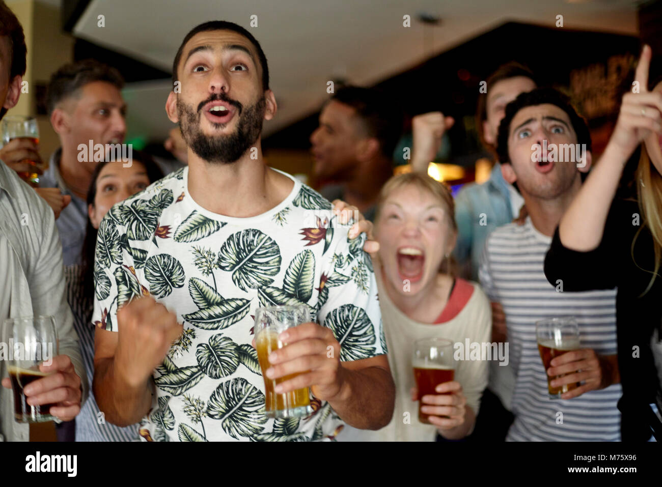 Gli appassionati di sport eccitato guardando la partita in bar Foto Stock