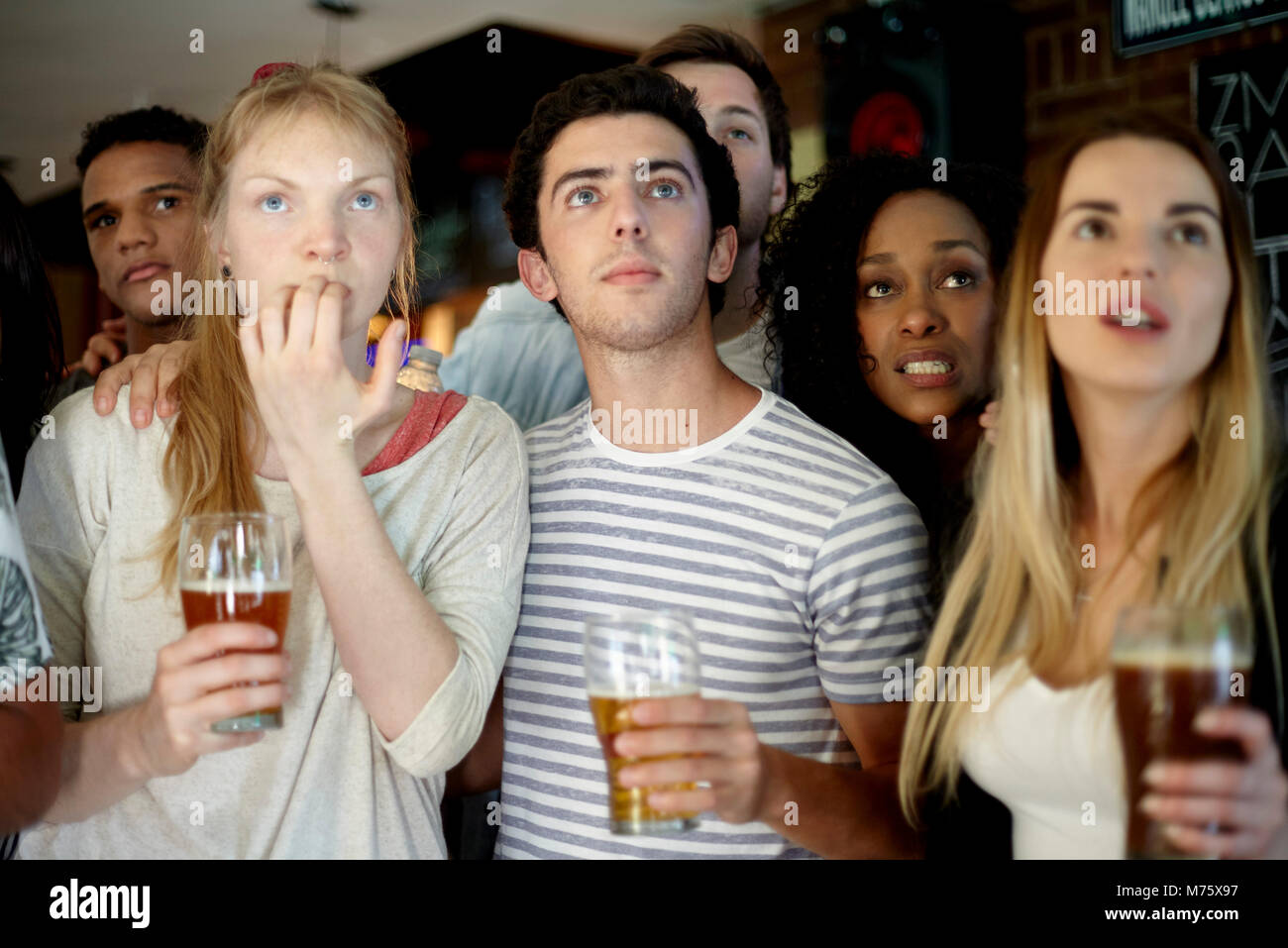 Gli appassionati di sport guardando la partita in bar Foto Stock