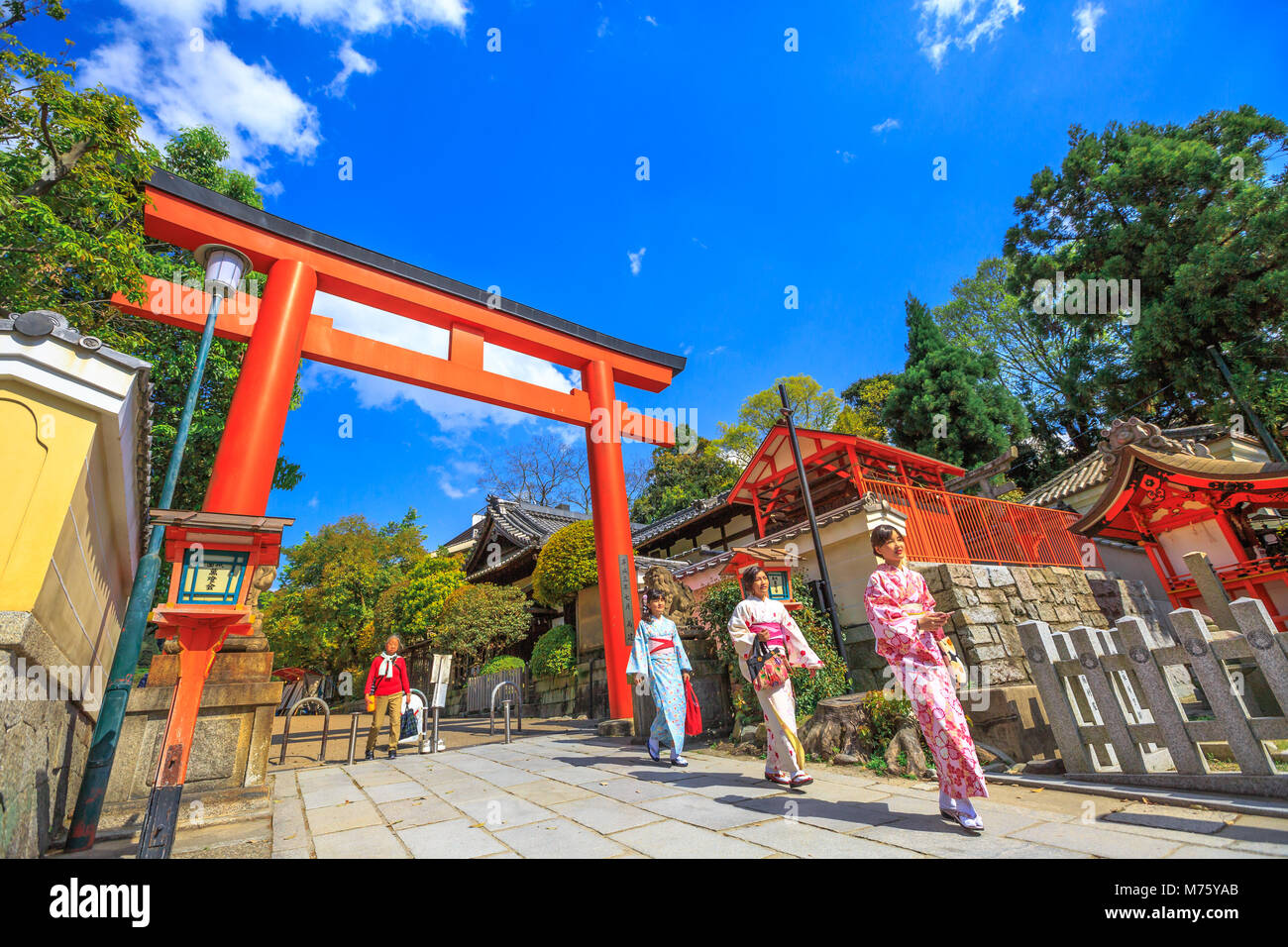 Kyoto, Giappone - 24 Aprile 2017: le donne giapponesi con il kimono al red Torii Gate del santuario Yasaka nella stagione primaverile. Gion Santuario è uno dei più famosi santuari tra Gion e Higashiyama District.giornata di sole Foto Stock