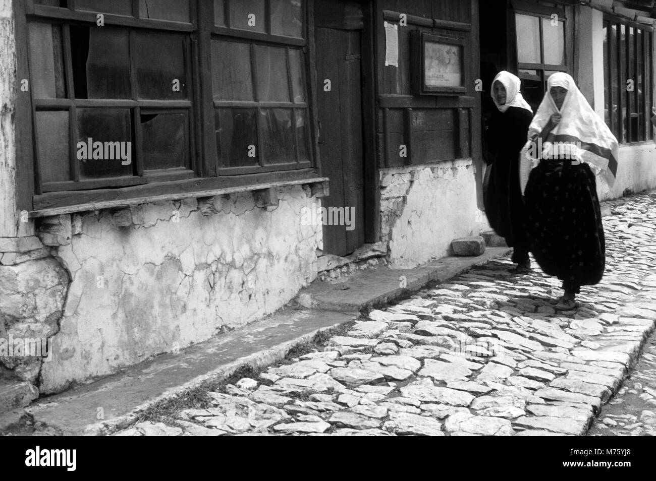 Due donne che camminando per le strade di ciottoli di Kruje in Albania 1966 Foto Stock