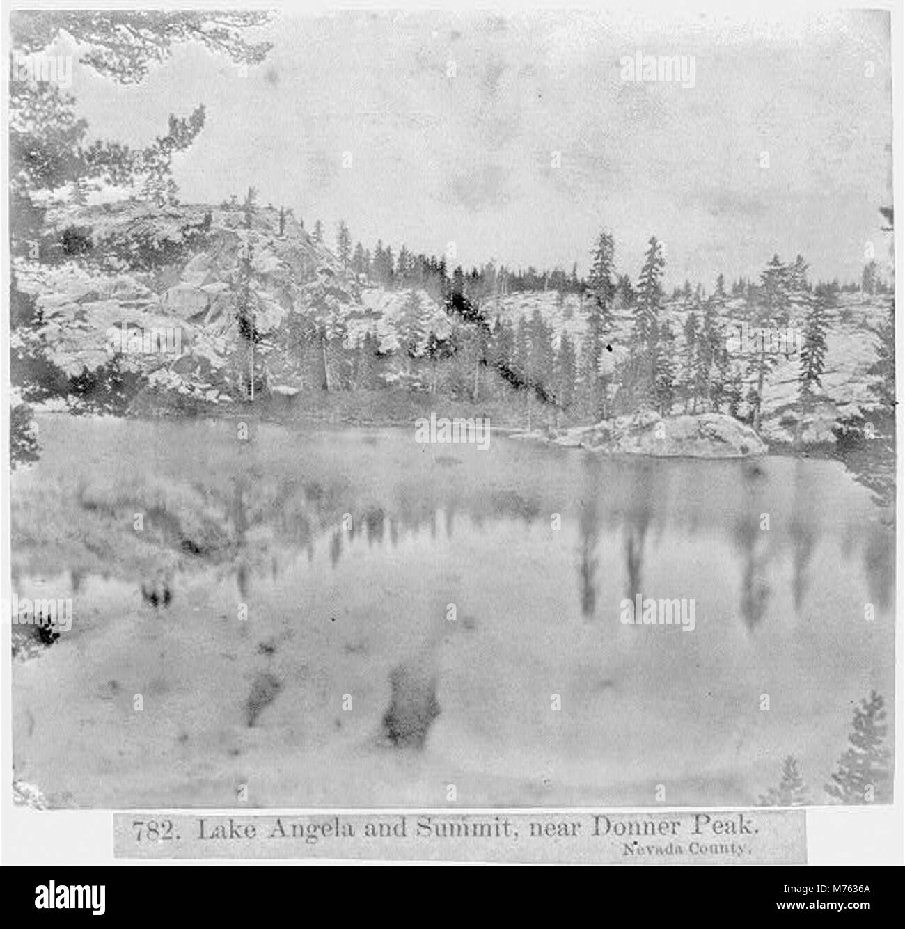 Il lago Angela, situato vicino a Donner Peak nella contea di Nevada, offre vedute panoramiche delle montagne circostanti e della natura selvaggia. La cima è una caratteristica notevole della zona, attirando i visitatori per attività all'aperto come escursioni e visite turistiche. Questa zona fa parte della regione della Sierra Nevada della California, conosciuta per i suoi paesaggi aspri e la bellezza naturale. Foto Stock