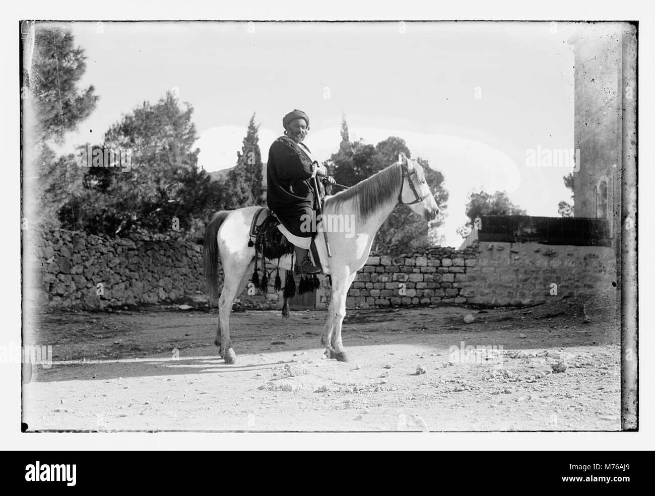 Questa immagine raffigura un uomo musulmano a cavallo, che illustra l'abbigliamento tradizionale e le pratiche culturali del periodo. La fotografia riflette l'identità storica e culturale del soggetto. Foto Stock