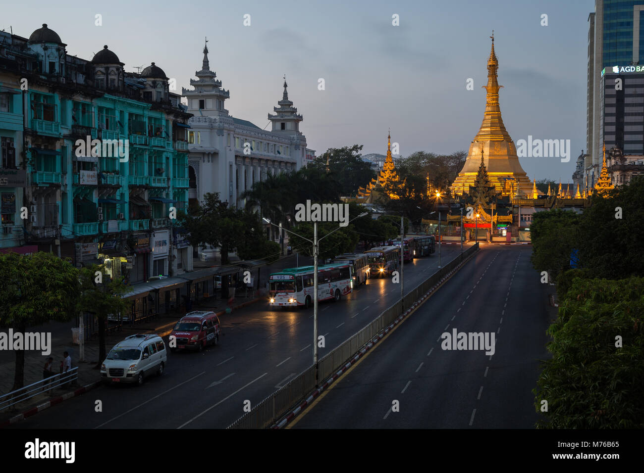 Vista della vecchia era coloniale edifici lungo le Sule Pagoda Road e illuminato Sule Pagoda nel centro di Yangon (Rangoon), Myanmar (Birmania), all'alba. Foto Stock