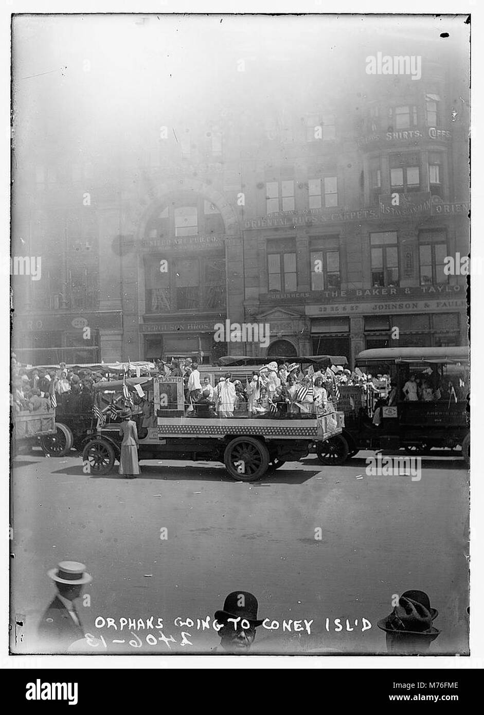 Una fotografia che mostra un gruppo di orfani in viaggio verso Coney Island, catturando un momento del loro viaggio. Questa immagine mette in evidenza la loro migrazione, probabilmente correlata a un'escursione estiva o a un evento di beneficenza, popolare all'inizio del XX secolo. Foto Stock
