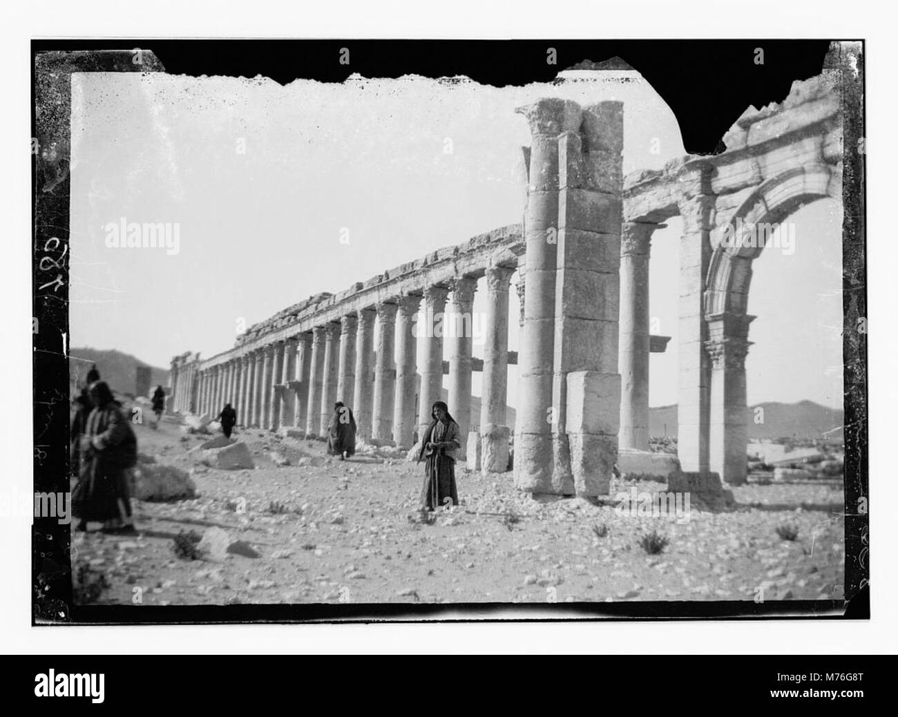 La fotografia mostra la metà occidentale del colonnato a Palmira (antica Tadmor) in Siria, evidenziando l'arco centrale di questo antico sito romano. Foto Stock