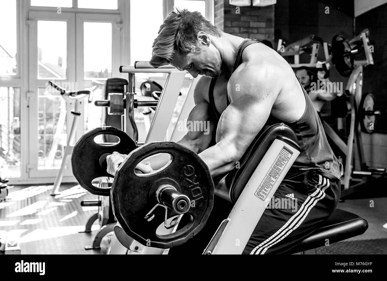Muscolare di uomo che lavora fuori con pesi nella palestra Foto Stock