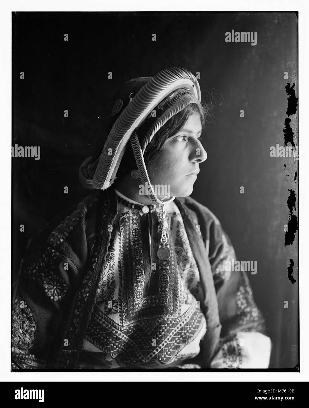 Una contadina del distretto di Ramallah è mostrata con indosso un copricapo di moneta in dote, un elemento tradizionale della cultura palestinese. Il copricapo è un importante simbolo dell'identità e del patrimonio culturale della regione. Foto Stock