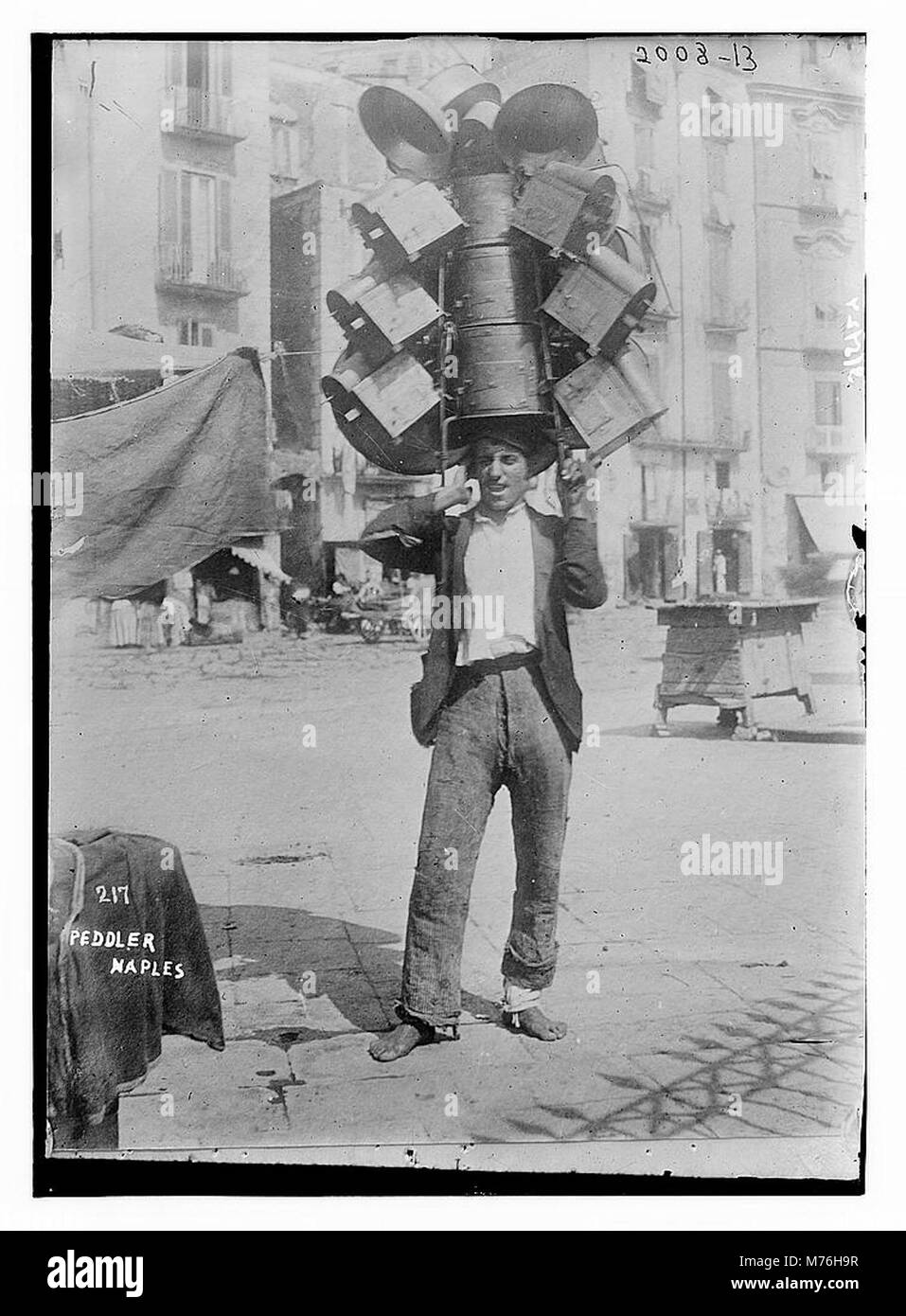 Questa fotografia cattura un venditore ambulante a Napoli, in Italia. Rappresenta una scena di strada della vita quotidiana, che mostra il ruolo tradizionale dei venditori ambulanti nella vibrante cultura del mercato della città. Foto Stock