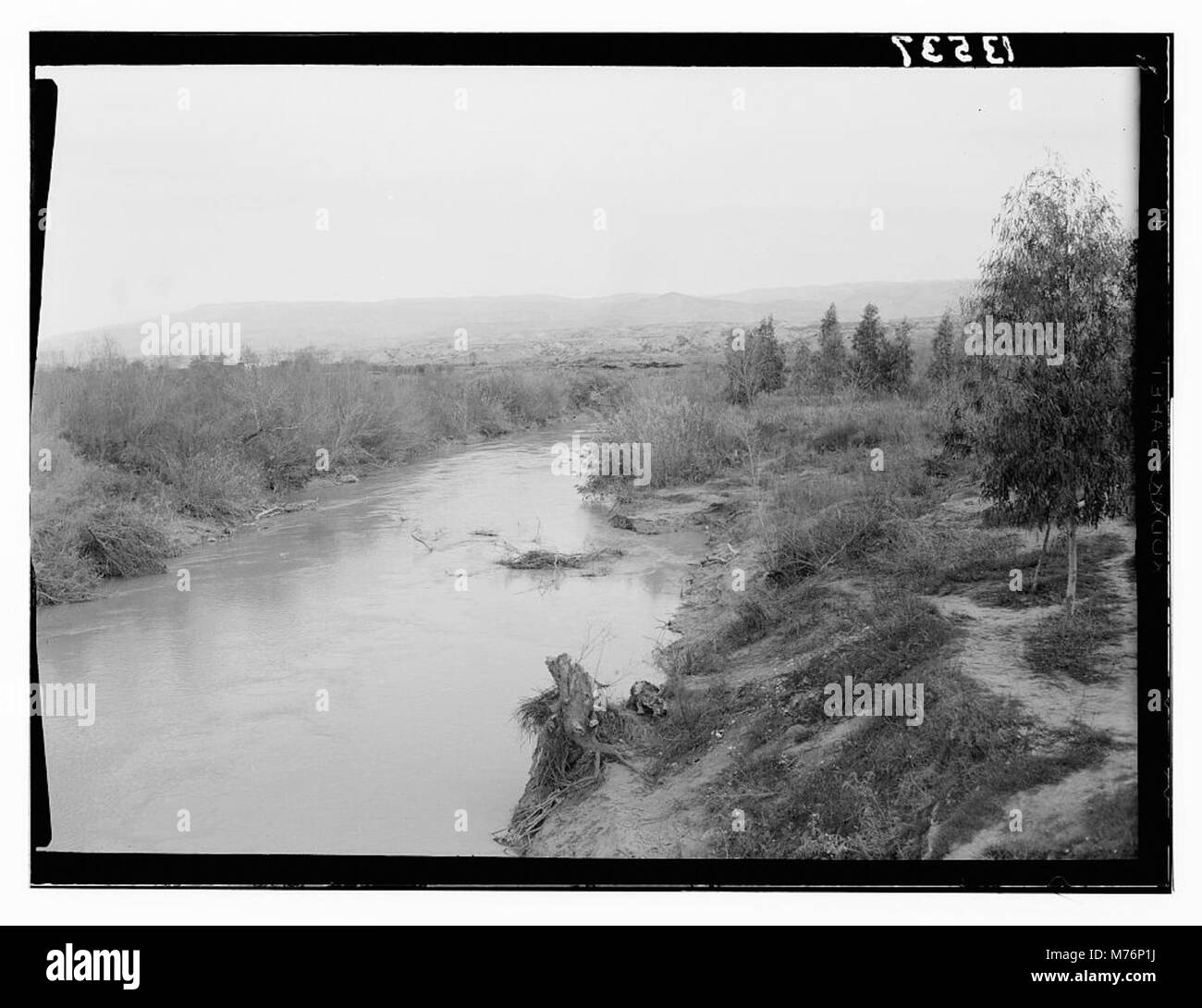 Questa immagine mostra la vista del fiume Giordano dal ponte Allenby, un sito significativo in Medio Oriente che collega Israele e Giordania. Foto Stock