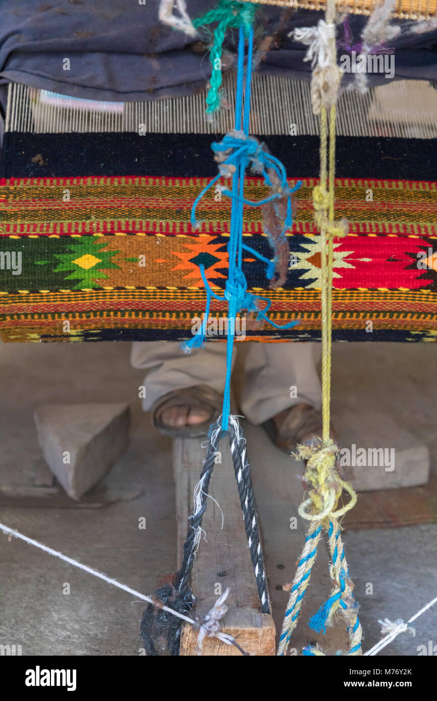 San Miguel del Valle, Oaxaca, Messico - un tappeto tessitore aziona i pedali su un telaio di tessitura. La donna ha ricevuto prestiti di microfinanza dal nonpro Foto Stock