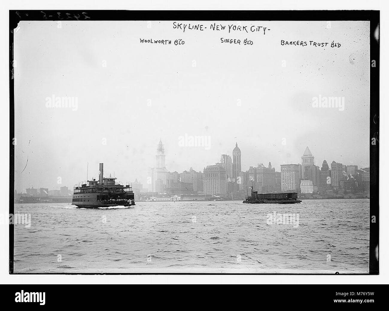 Questa fotografia mostra lo skyline di New York City, che mostra in modo preminente il Woolworth Building, il Singer Building e il Bankers Trust Building. L'immagine mostra la crescita architettonica di New York durante l'inizio del XX secolo. Foto Stock