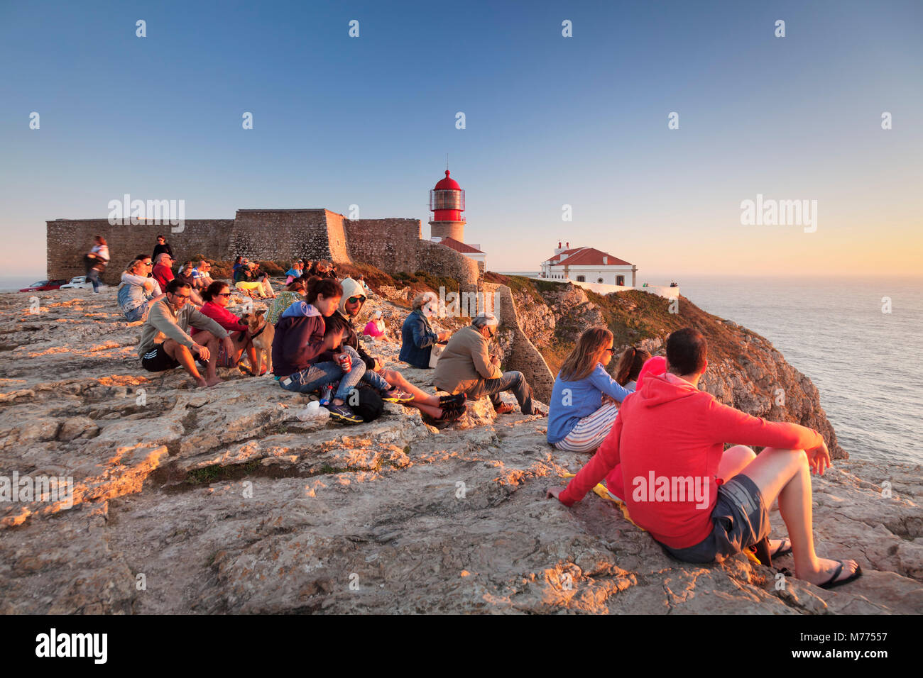 I turisti godersi il tramonto al faro di Cabo de Sao Vicente, Sagres Algarve, Europa Foto Stock