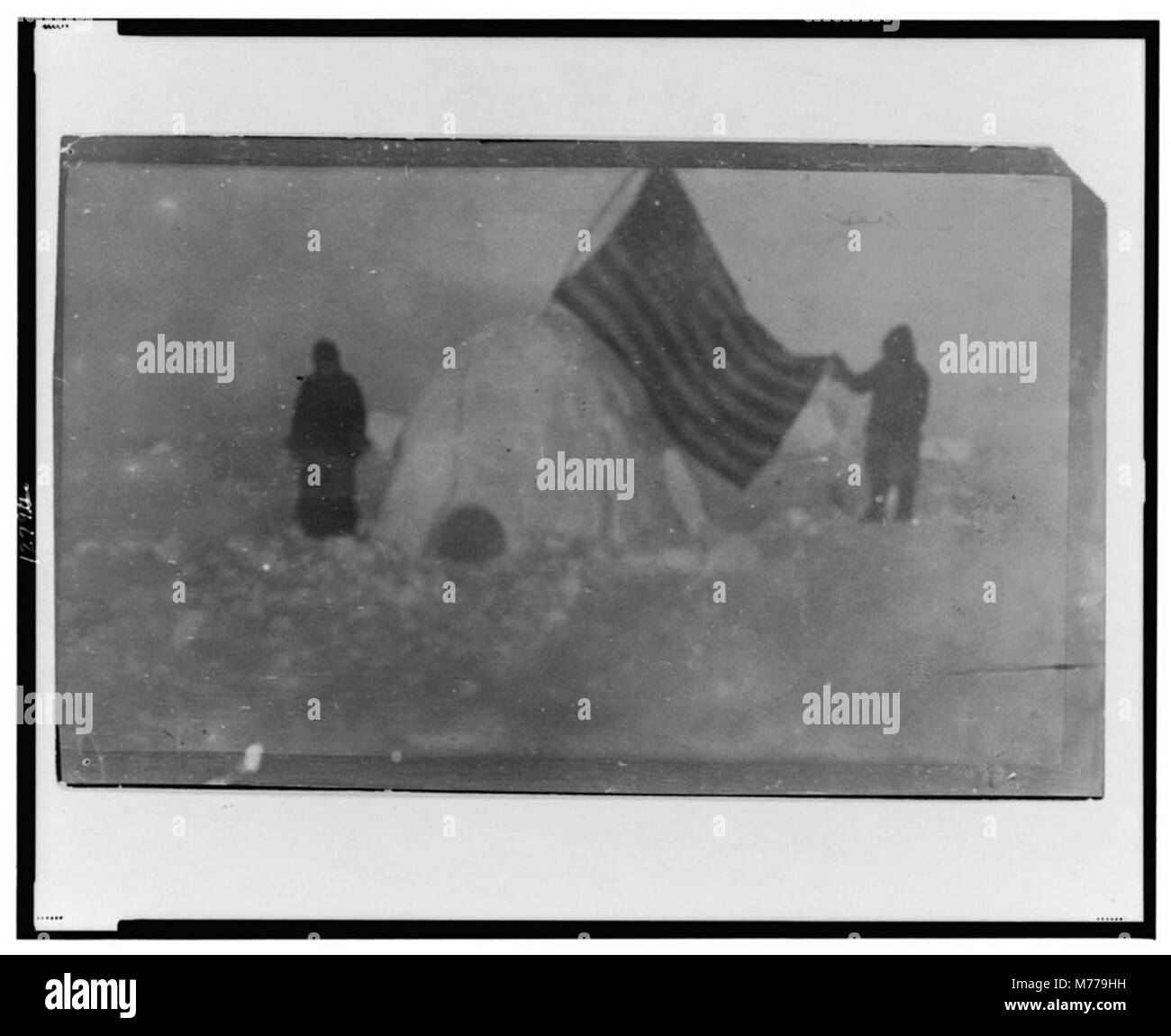 Due membri della spedizione al Polo Nord di Frederick Cook sono mostrati in questa fotografia, con la bandiera degli Stati Uniti piantata in un igloo nel campo. Foto Stock