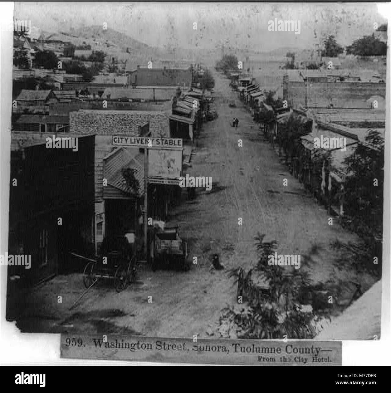 Questa immagine storica mostra Washington Street a Sonora, Tuolumne County, California, vista dal City Hotel. La strada, fiancheggiata da edifici, riflette lo sviluppo della città durante la fine del XIX secolo. Foto Stock