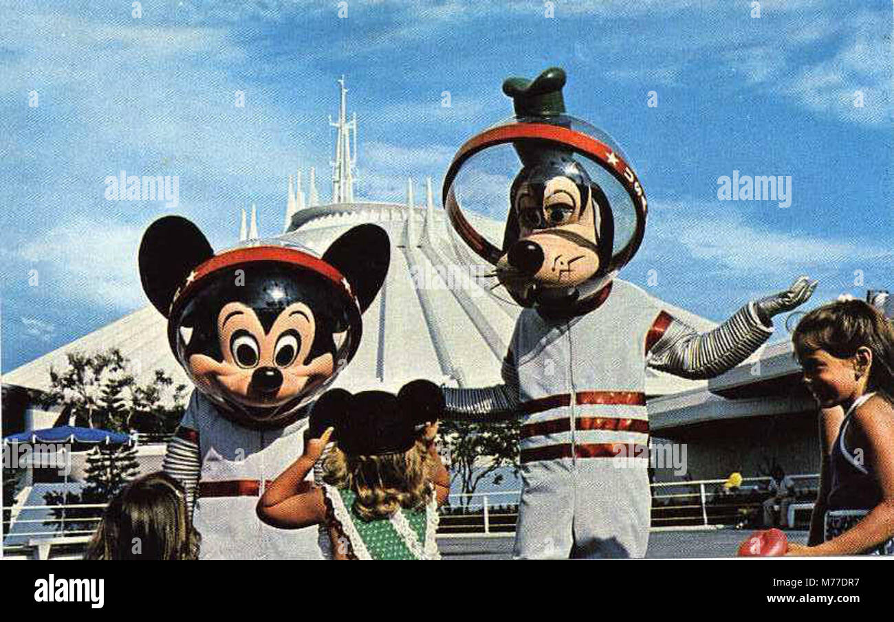 Un'immagine vibrante che promuove Disney World, con personaggi iconici come Topolino e Pippo con il futuristico viaggio sulla montagna spaziale. Questo cattura la magia e l'intrattenimento dei primi anni del parco a tema. Foto Stock