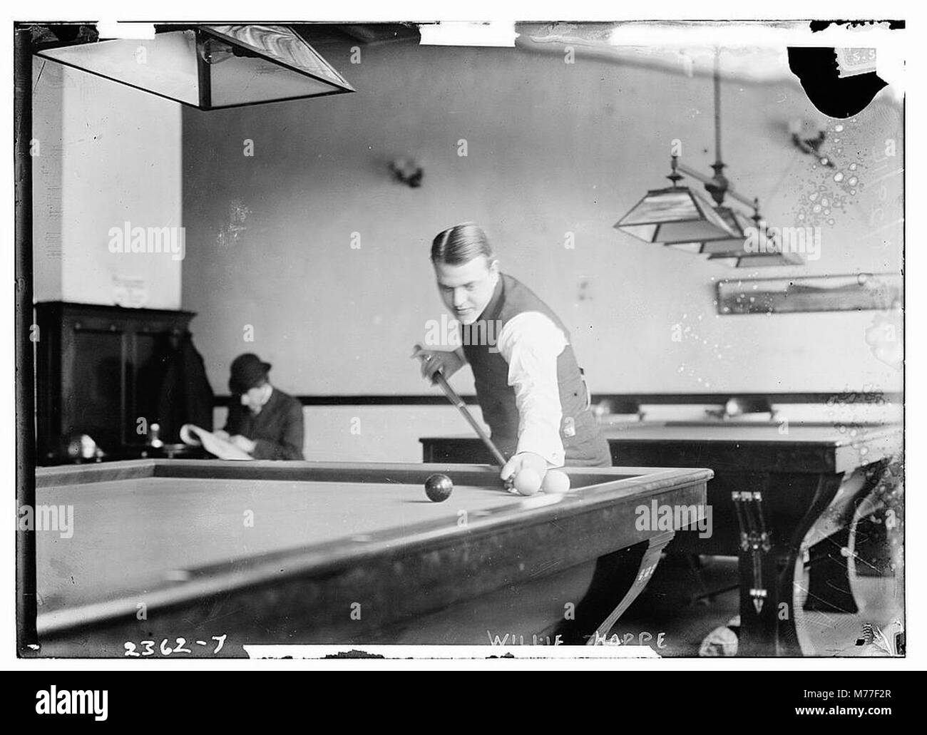 Willie Hoppe era un giocatore di biliardo campione del mondo noto per la sua eccezionale abilità nello sport. Questa immagine lo cattura durante una partita, dimostrando la sua padronanza nei biliardi. Foto Stock