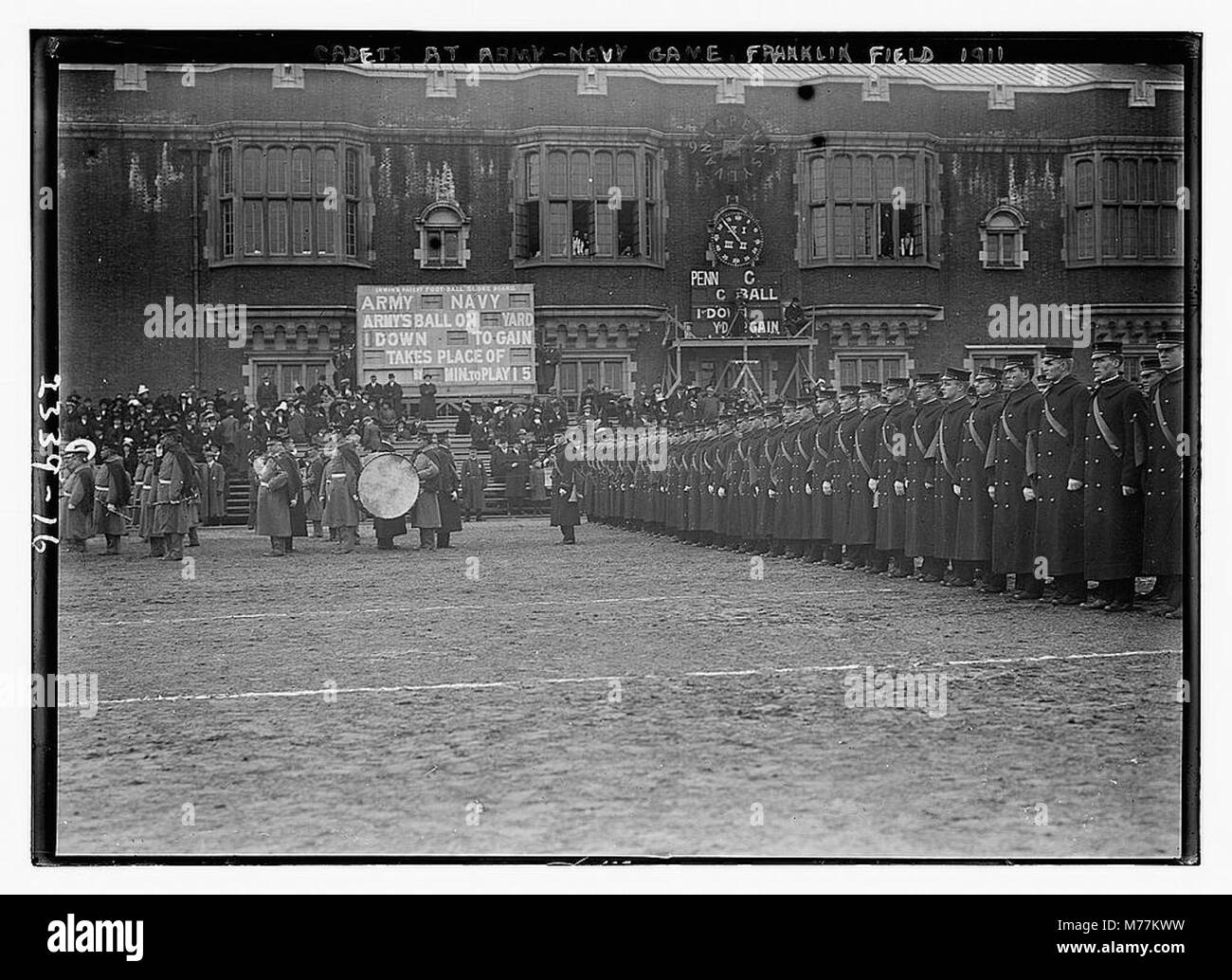 Un gruppo di cadetti militari è raffigurato durante la partita di football tra esercito e marina al Franklin Field nel 1911. L'evento cattura la tradizione del calcio collegiale e il coinvolgimento delle accademie militari nella cultura sportiva degli Stati Uniti. Foto Stock