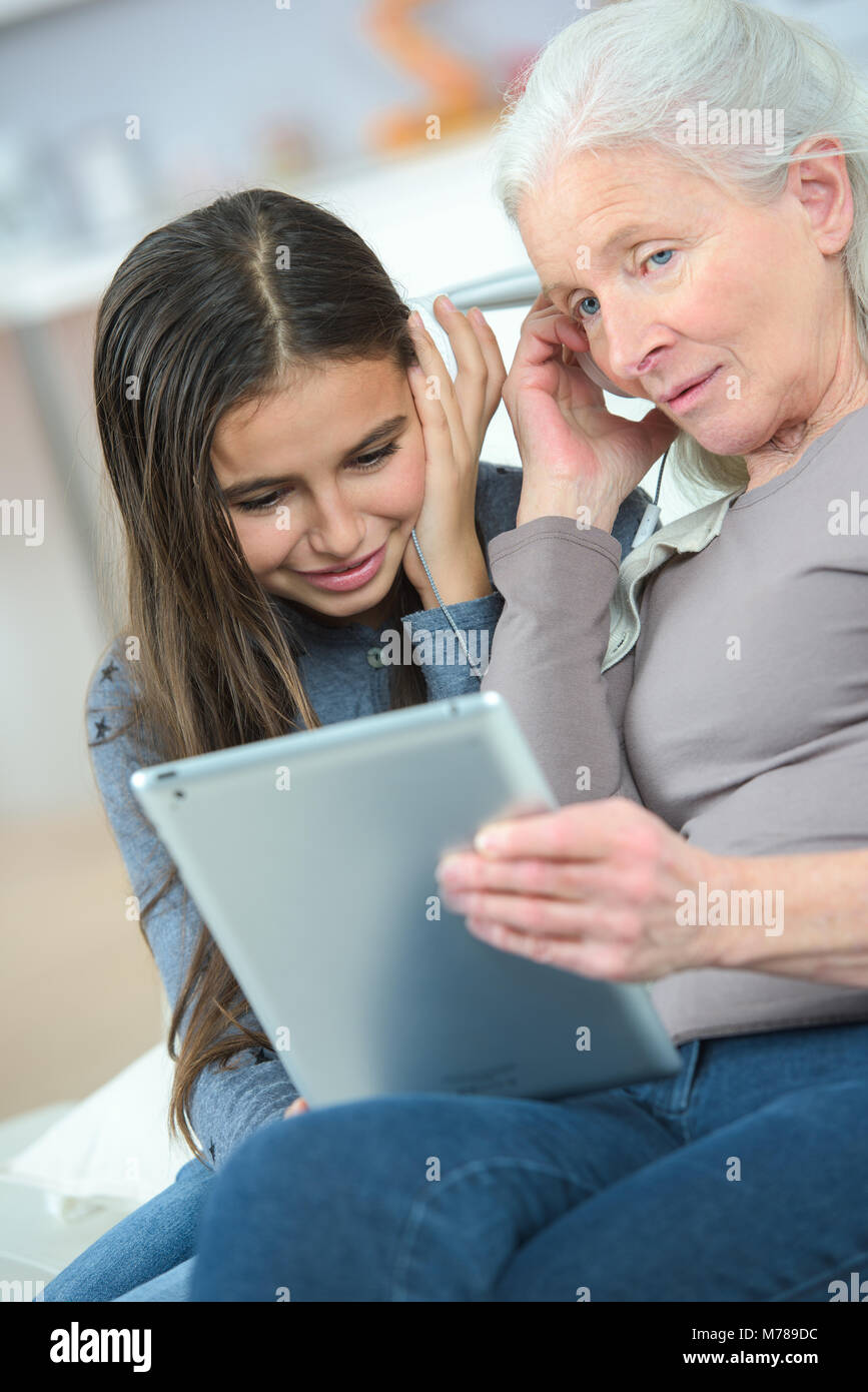 La nonna e la figlia ascoltando le cuffie Foto Stock