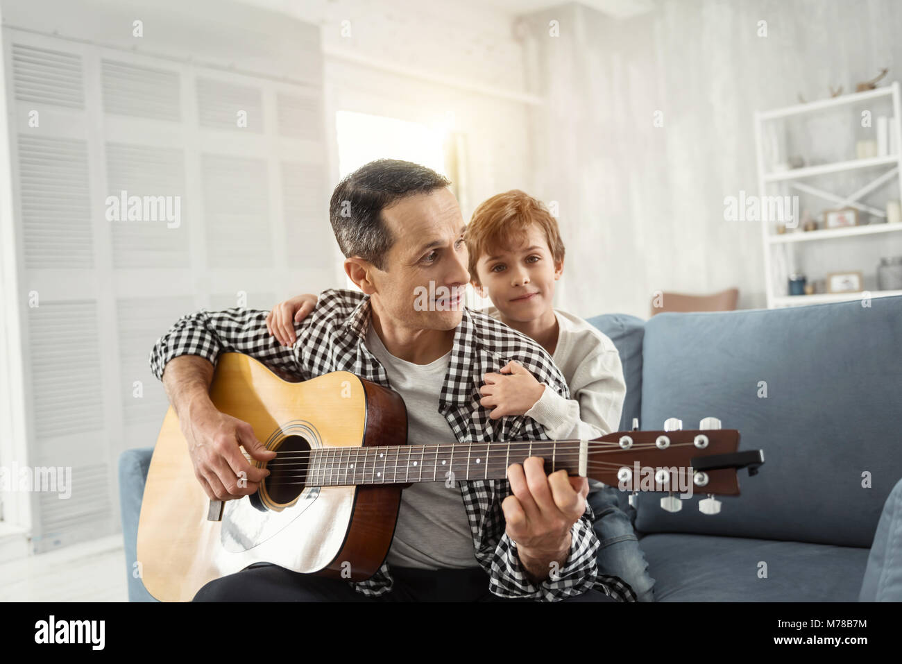 L uomo ha ispirato a suonare la chitarra per suo figlio Foto Stock