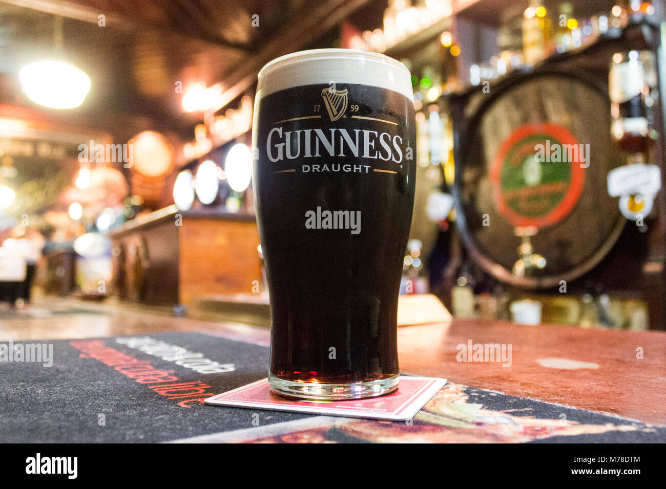 Una pinta di Irish dry stout Guinness oltre il contatore della casa di McDonnell, un pub tradizionale a Ballycastle, County Antrim, Irlanda del Nord Foto Stock
