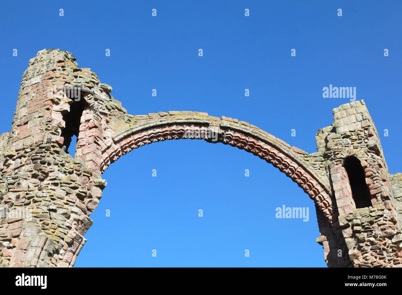 L'arcobaleno arco di Lindisfarne Priory Chiesa, Isola Santa. Foto Stock