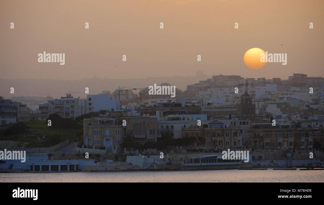 Il sole che tramonta sulla Valletta a Malta Foto Stock
