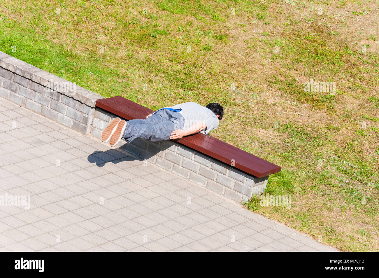 Fasciame gioco di sfida. Uomo cercando di stabilire su banco trasversalmente come plancia e a non passare un po' di tempo Foto Stock