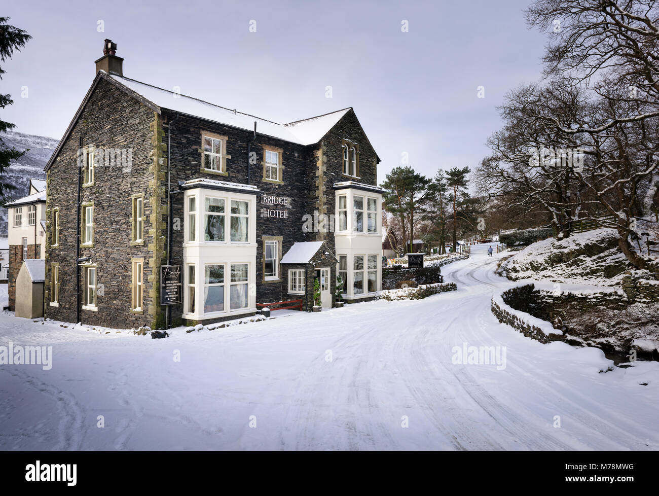 Neve invernale coperto village Road presso l'Hotel Bridge in Buttermere nel Lake District inglese Foto Stock