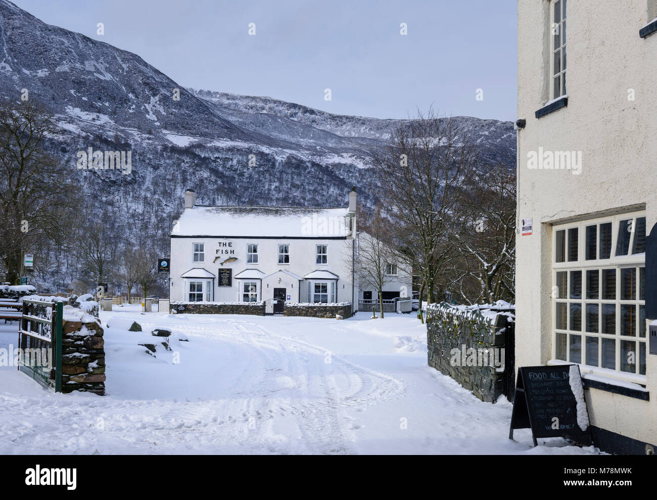 Neve invernale coperto village strada per il pesce Inn in Buttermere nel Lake District inglese Foto Stock