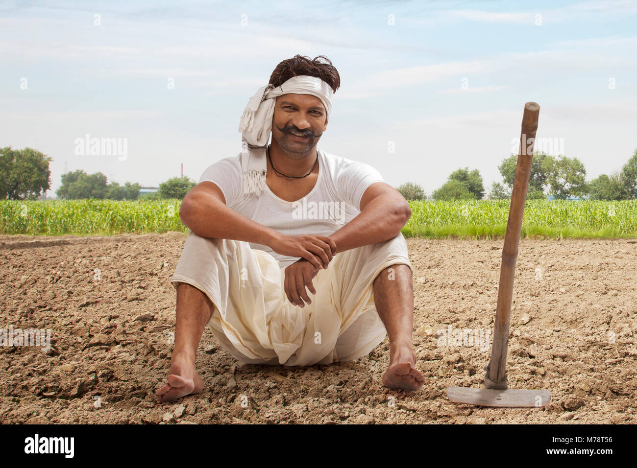 L'agricoltore è seduta in campo con la zappa Foto Stock