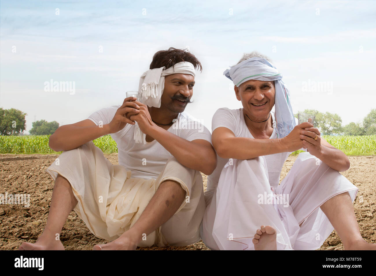 Due agricoltori seduta nel campo bere il tè Foto Stock