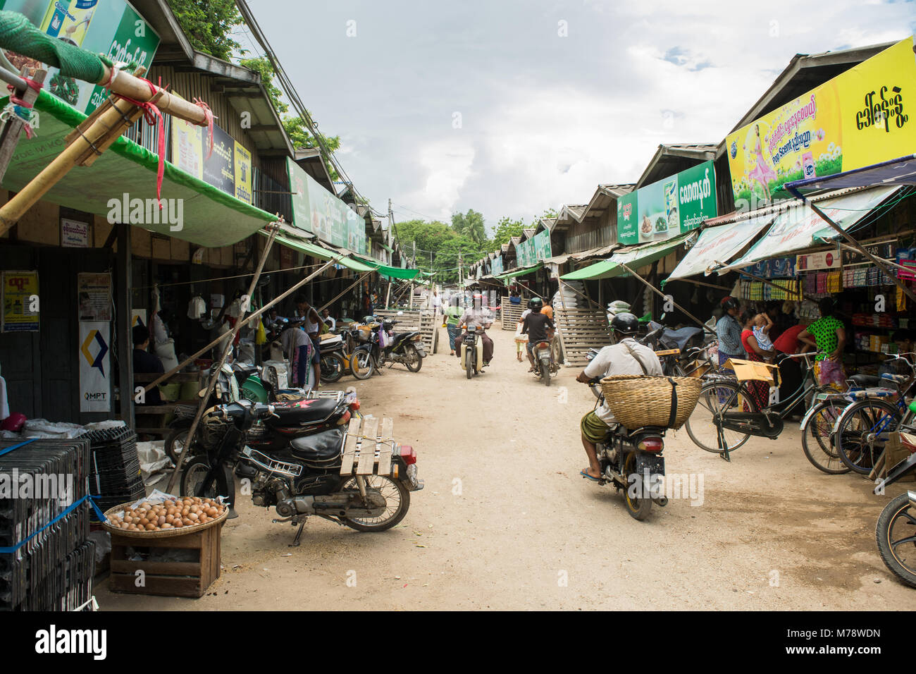Strada di Nyaung U locale e tradizionale mercato asiatico con il popolo birmano in moto con possibile cesto storage acquistano merci, Bagan, MYANMAR Birmania, SE Asia Foto Stock