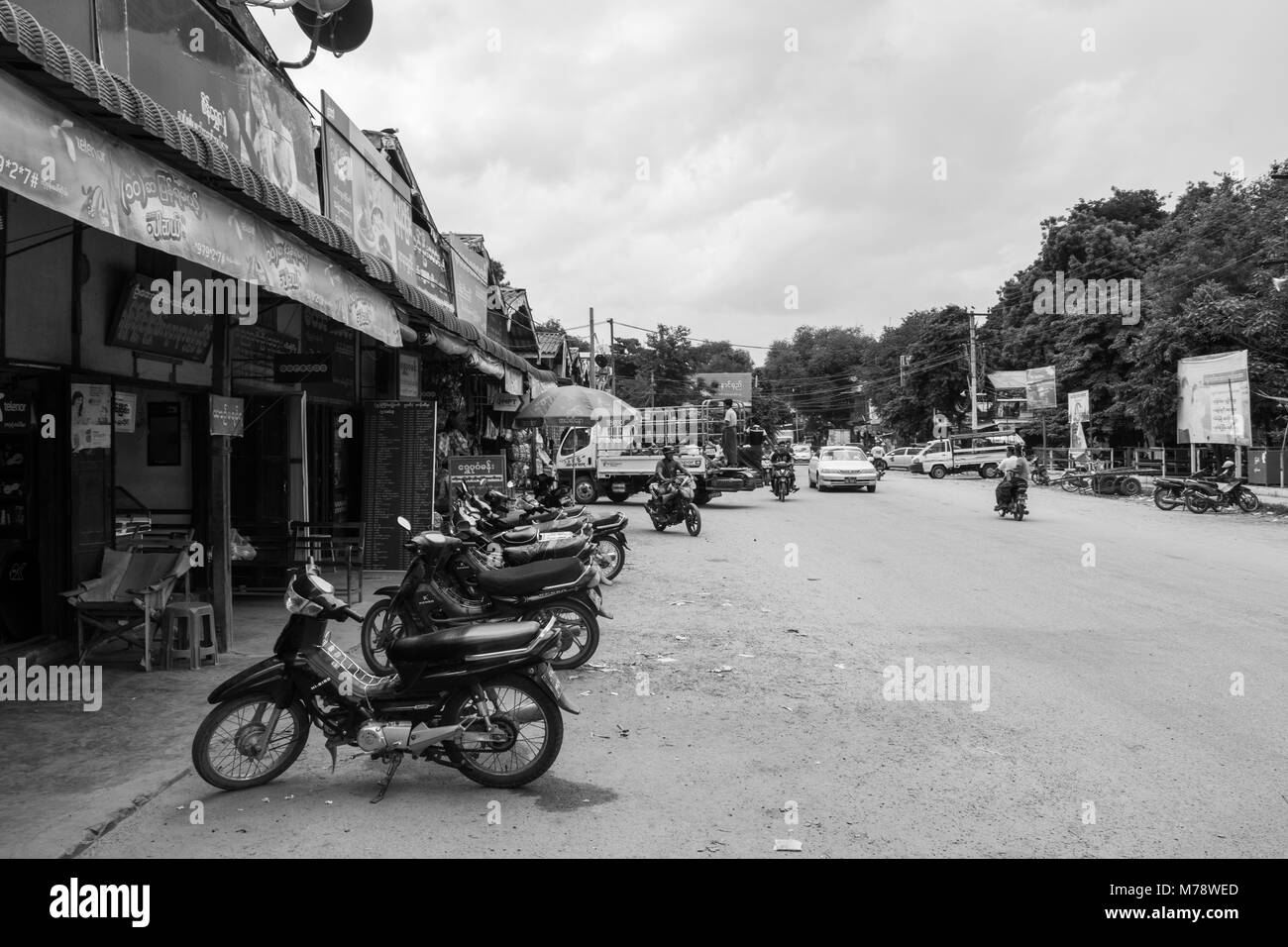 Una strada di sabbia accanto a Nyaung U mercato vicino a Bagan, MYANMAR Birmania. le bancarelle del mercato e parcheggiata motocicli, modalità di trasporto comune nel Sud Est asiatico Foto Stock