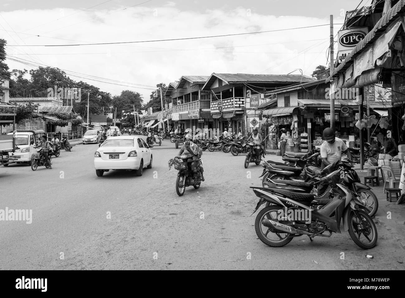 Una strada di sabbia accanto a Nyaung U mercato vicino a Bagan, MYANMAR Birmania. le bancarelle del mercato e parcheggiata motocicli, modalità di trasporto comune nel Sud Est asiatico Foto Stock