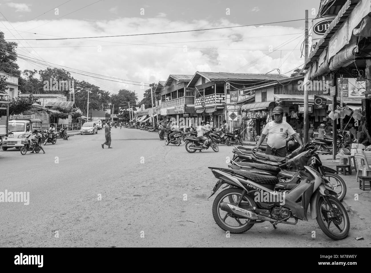 Una strada di sabbia accanto a Nyaung U mercato vicino a Bagan, MYANMAR Birmania. le bancarelle del mercato e parcheggiata motocicli, modalità di trasporto comune nel Sud Est asiatico Foto Stock