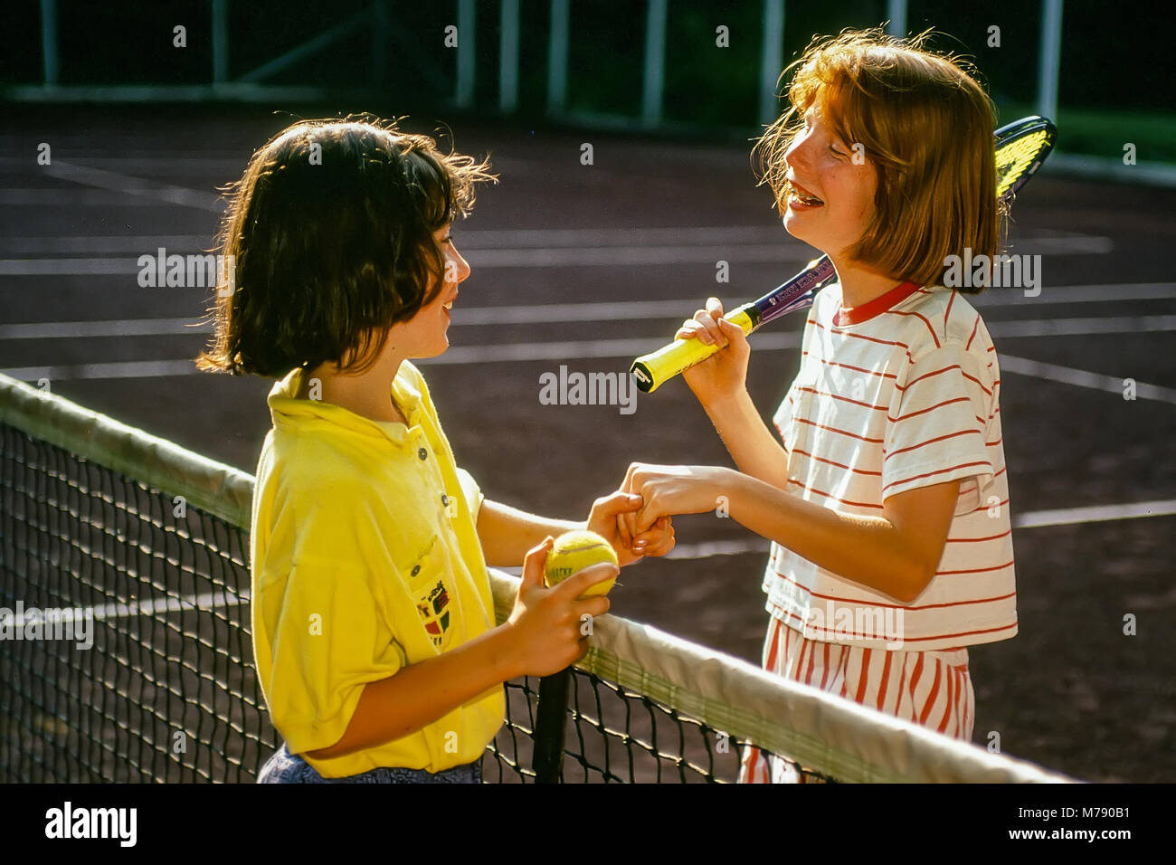 Felice Bambini ragazza mi congratulo con ogni altro dopo una partita di tennis al campo estivo in Vermont, Stati Uniti, Nord America. Foto Stock