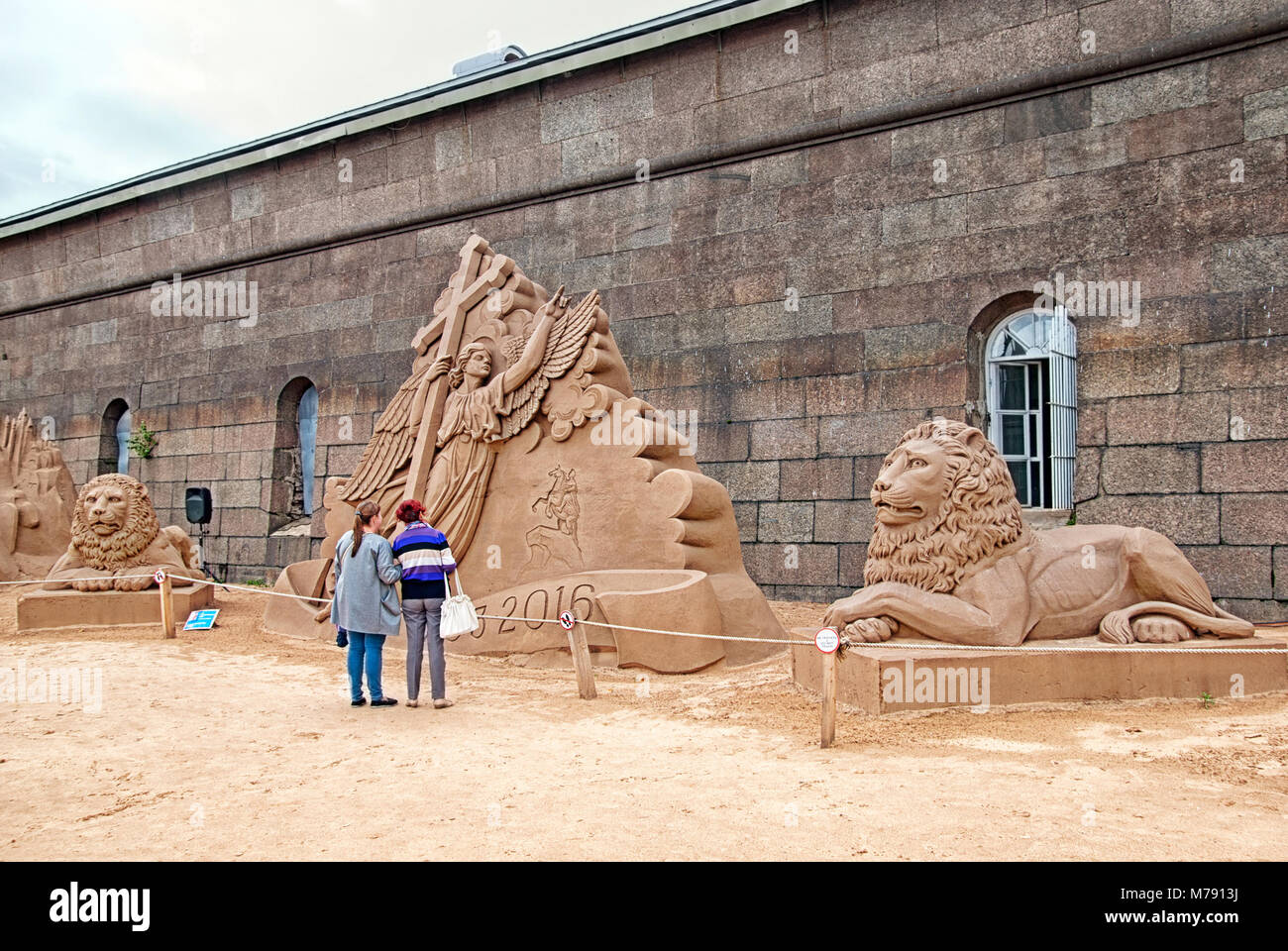 La gente guarda le sculture di sabbia sulla sabbia Sculpture Festival nei pressi della Fortezza di Pietro e Paolo la parete Foto Stock