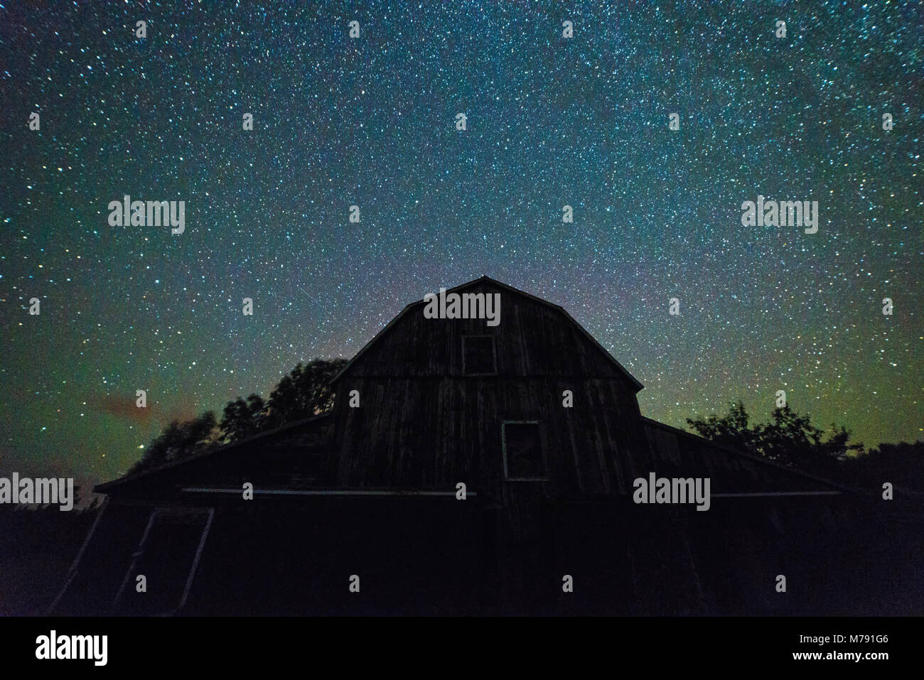 Vecchi fienili e annessi con cielo stellato con le nuvole e la via lattea nel periodo estivo Foto Stock