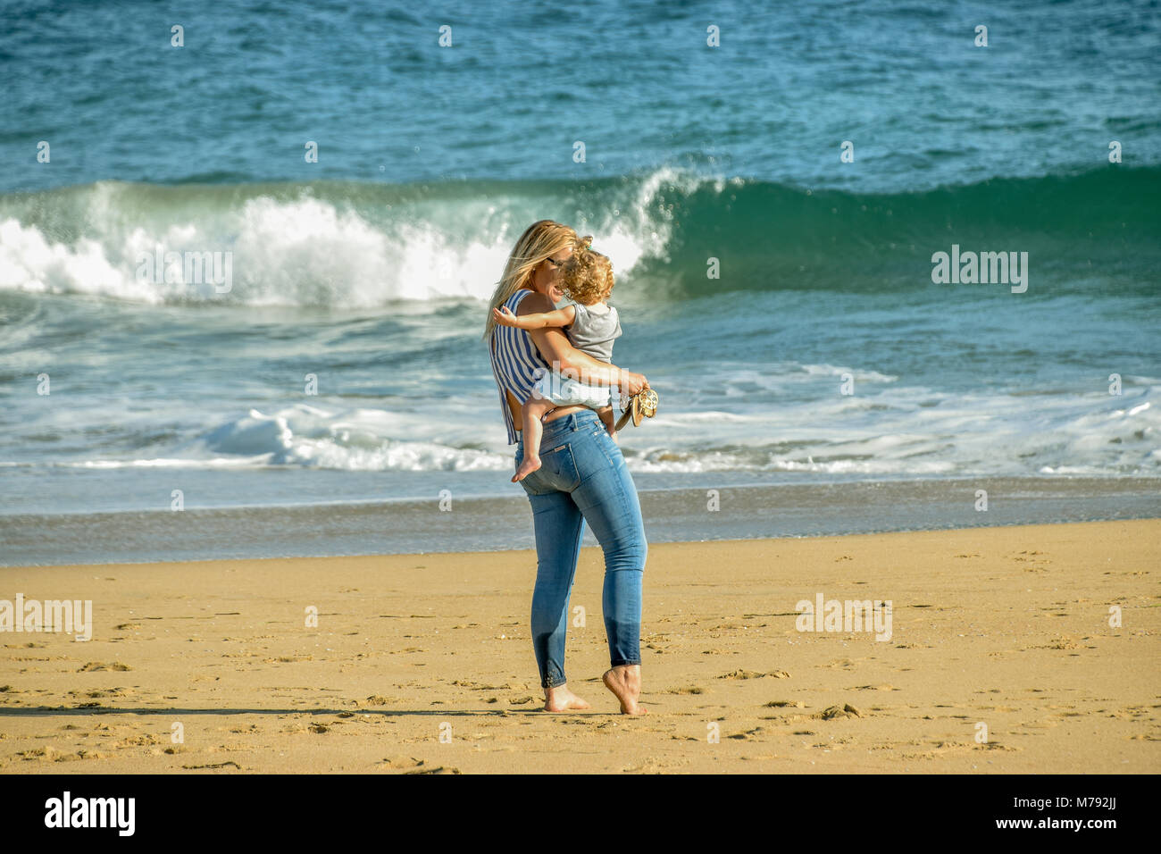 Una donna e suo figlio godendo di un giorno di estate sulla spiaggia sulla penisola di Balboa, Newport Beach, California. Foto Stock