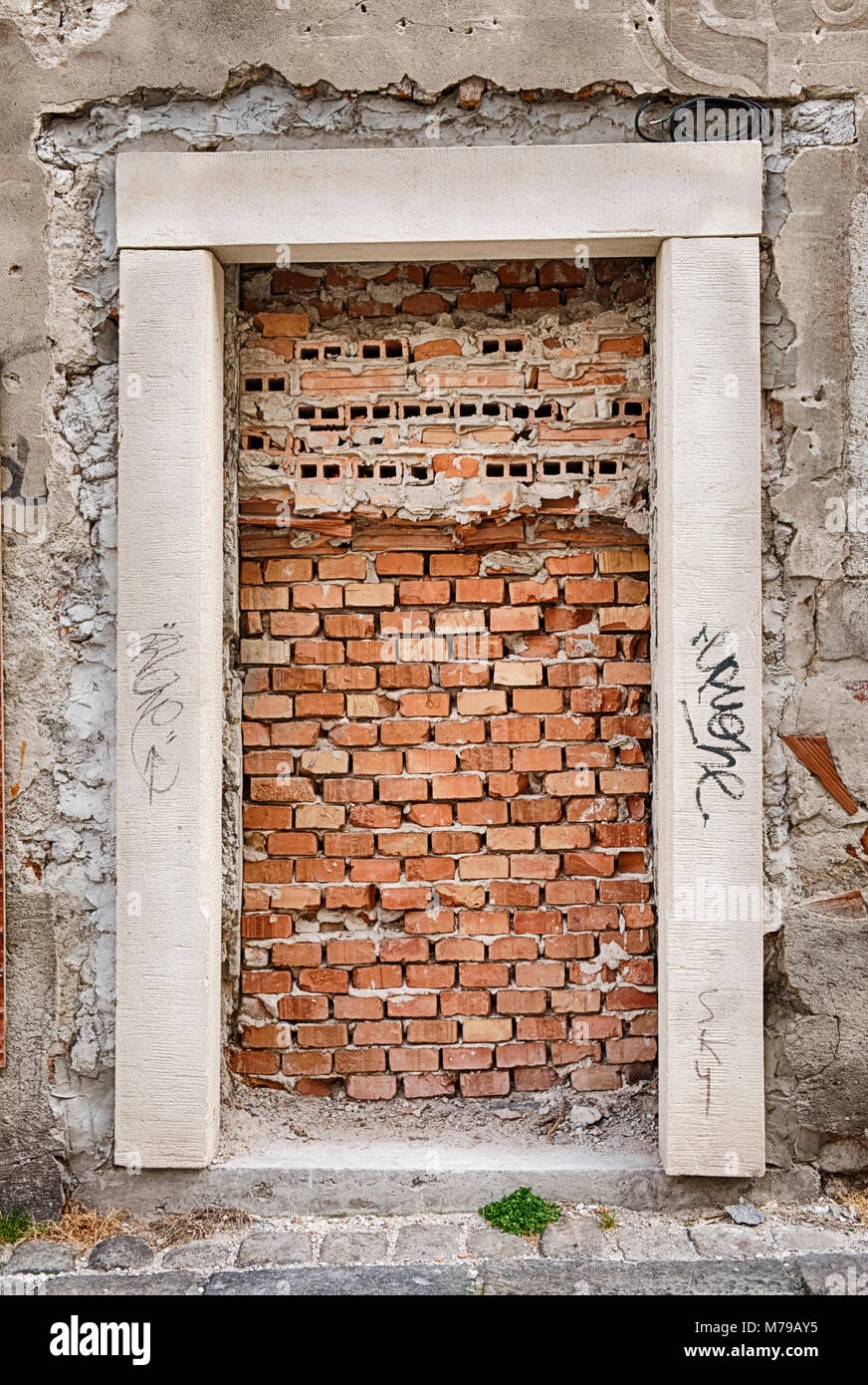 Una porta su un edificio nel centro storico di Bratislava, Slovacchia è briicked fino a formare un anello chiuso, dead-end ingresso. Una metafora simbolica. Foto Stock