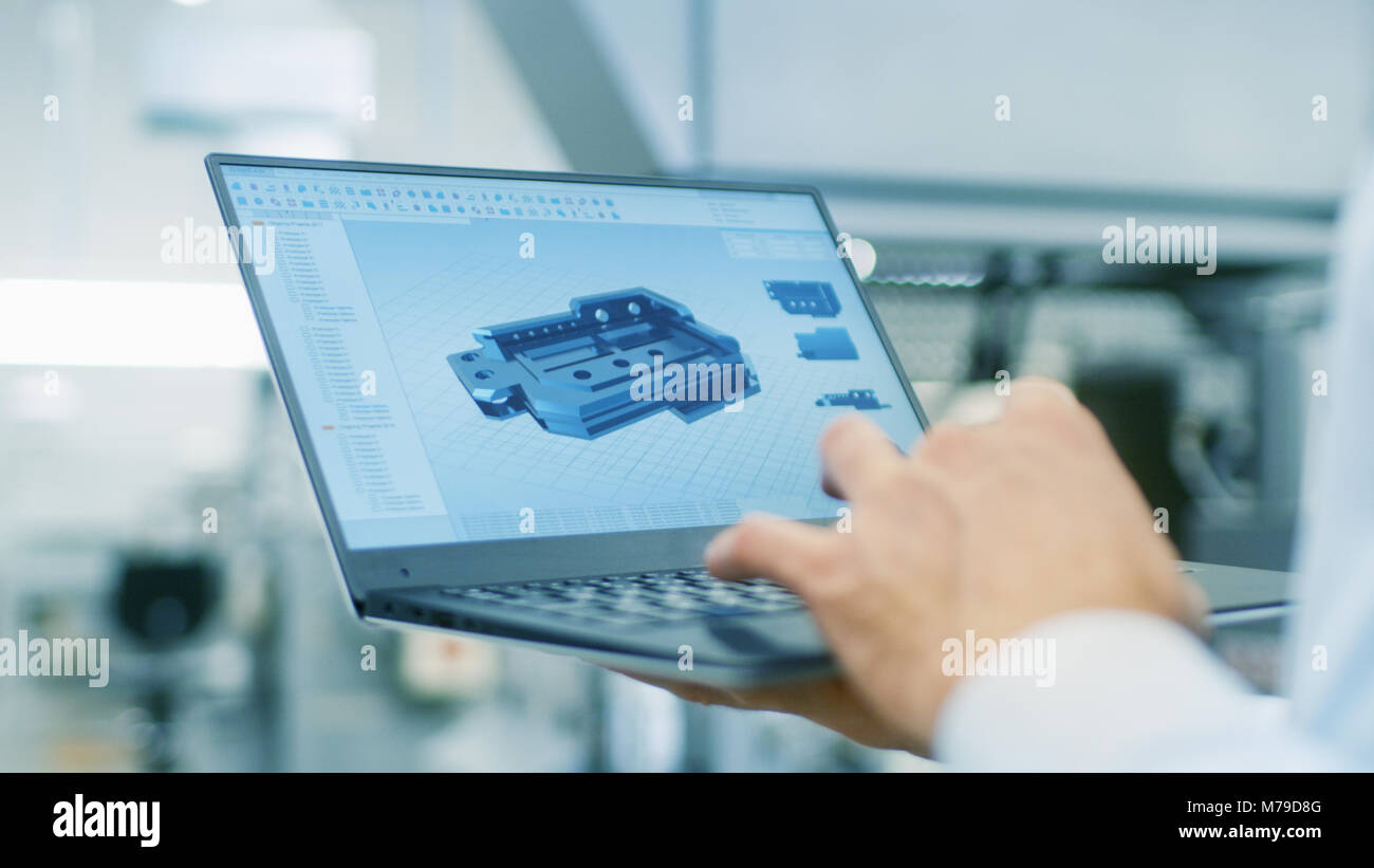Close-up dell'Ingegnere Azienda portatile con CAD modello di componente sullo schermo. In background moderno equipaggiamento di fabbrica. Foto Stock