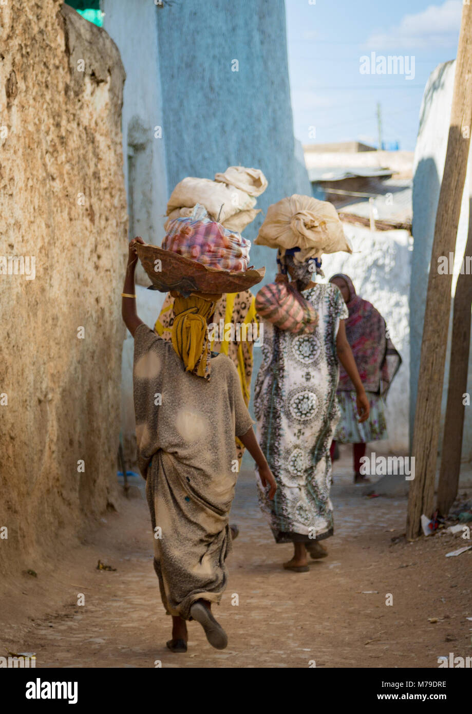 Donna che trasportano i loro negozi di generi alimentari sulla loro testa dopo il mercato, Harari regione, Harar, Etiopia Foto Stock