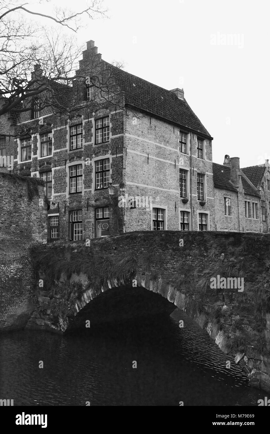 Meebrug: un antico ponte di pietra sul canal Groenerei in fondo Meestraat, portando in Groenerei e Steenhouwersdijk, Brugge, Belgio. Film in bianco e nero fotografia, circa 1985 Foto Stock