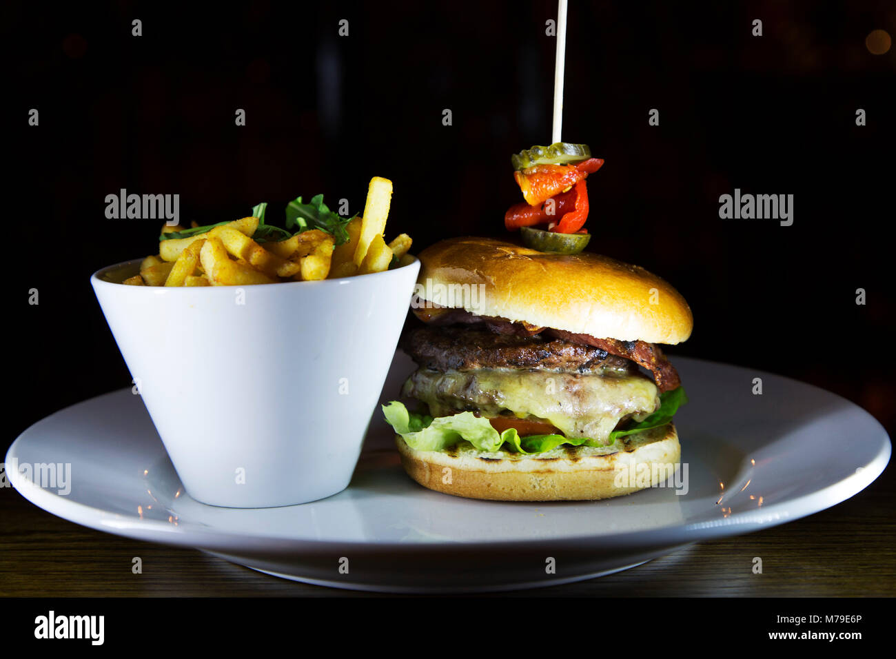 Formaggio hamburger servita a Sunderland, Inghilterra. Il Burger è servita con le patatine fritte in un recipiente. Foto Stock