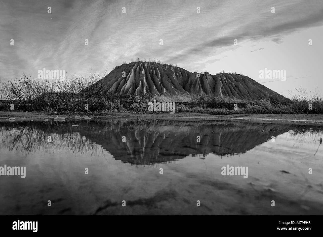 Montagna di cenere e la sua riflessione su un lago artificiale in Rummu, Estonia Foto Stock