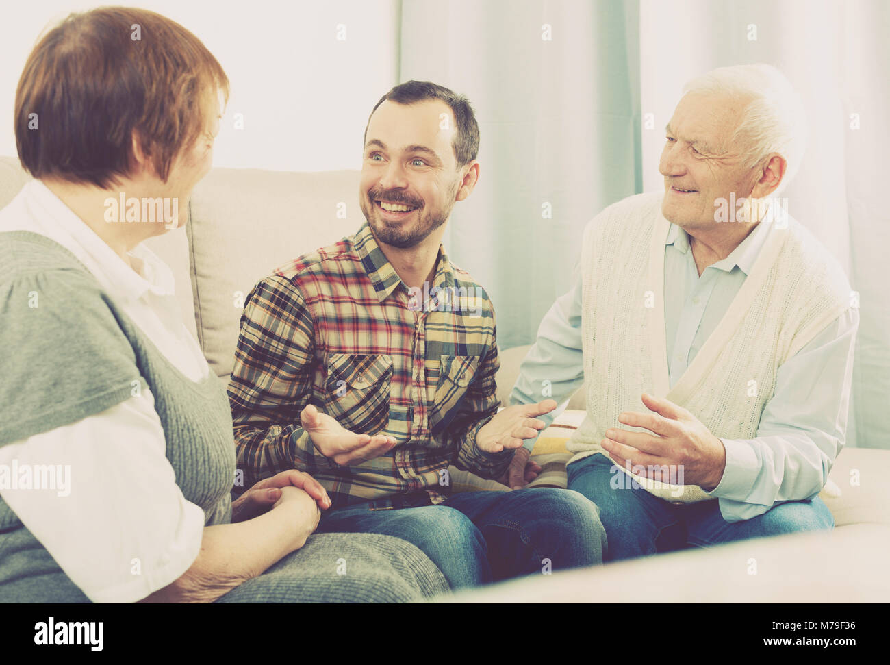 I nonni anziani conversazione amichevole con il nipote seduto sul divano Foto Stock