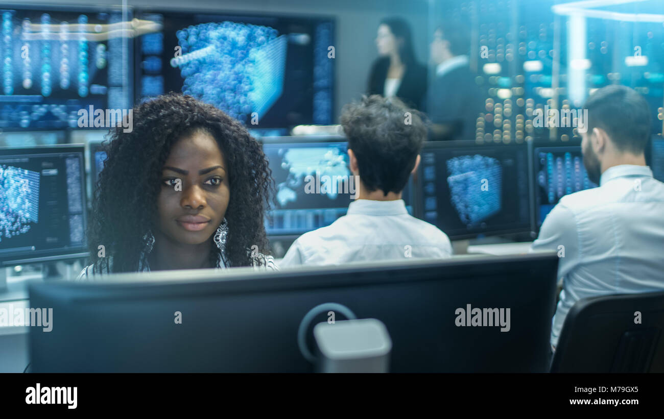 Femmina Ingegnere Informatico funziona su una rete neurale/ di intelligenza artificiale di un progetto con il suo team Multi-Ethnic di Specialista. Office è multi etnico Foto Stock